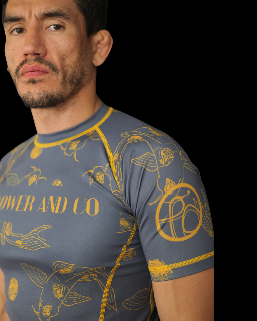 Man wearing a blue rashguard with gold koi fish  patterns and 'PAOWER AND CO' text.
