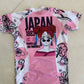 Pink and white garment with black floral patterns and 'Japan' text on a beige surface.