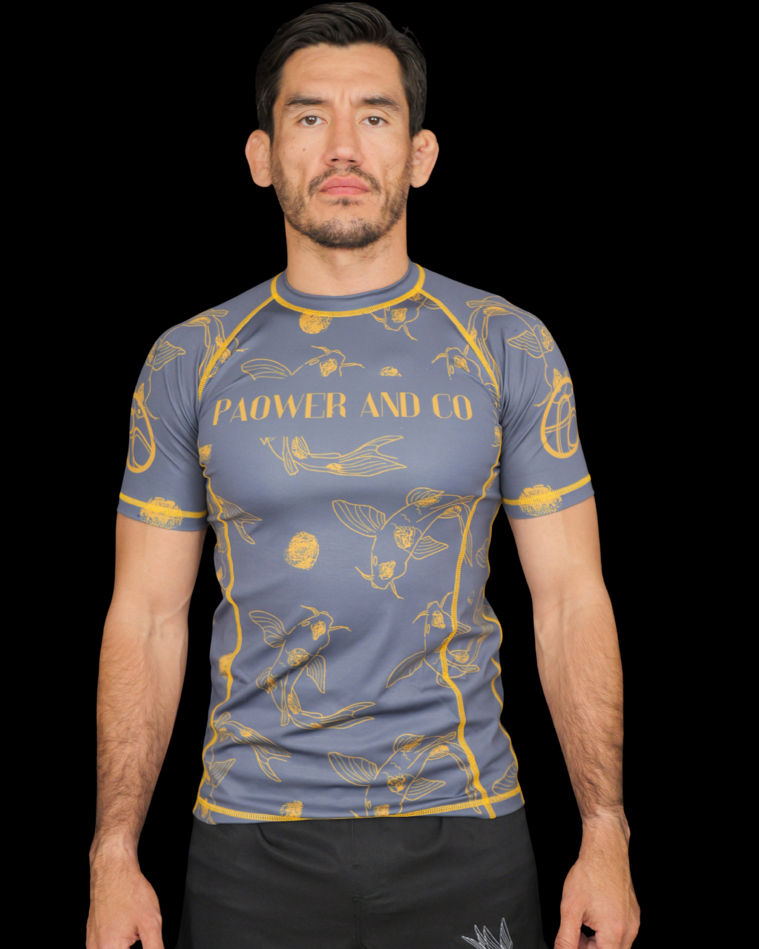 Man wearing a blue athletic shirt with yellow patterns and paower and co text on the chest 